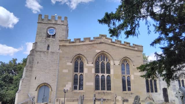 St Peter's Brafferton C of E V A Primary School, featuring stone architecture, a clock tower, and surrounding gravestones.