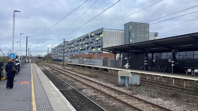 Bus stops at Wakefield Westgate with railway tracks, modern buildings, and cloudy skies in the background.
