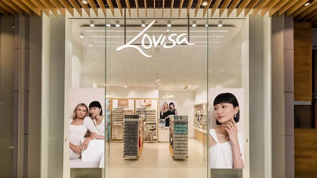 Jewellery store entrance with large glass doors, bright displays, and promotional images of models showcasing accessories.