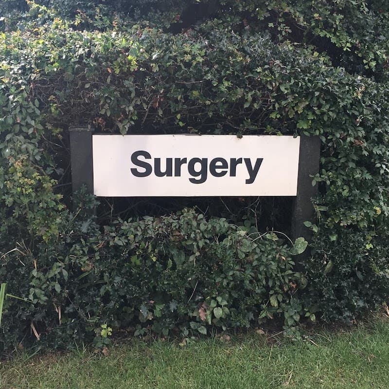Sign reading "Surgery" surrounded by lush greenery at Ayton & Snainton Medical Practice in East Ayton, Yorkshire.