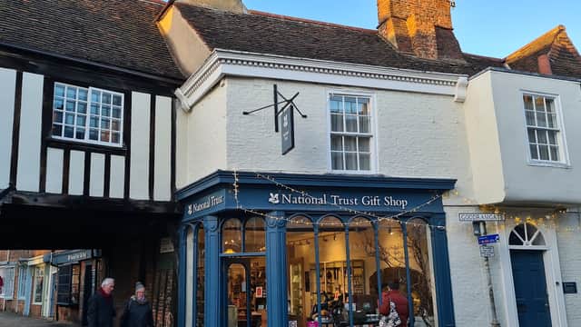 National Trust Gift Shop with blue signage, displaying various items, in a historic building in York, Yorkshire.