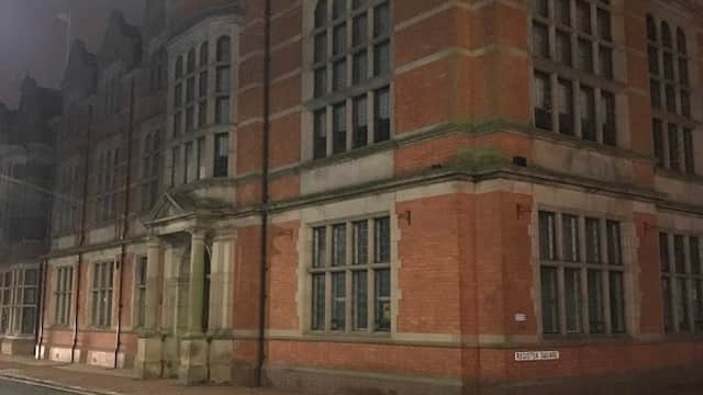Historic brick building with large windows, corner tower, and street view in Beverley, Yorkshire at night.