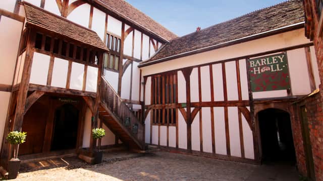 Tudor-style courtyard with timber-framed buildings, wooden staircase, and Barley Hall sign.