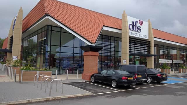 Modern furniture store with large glass windows, red tiled roof, and parking area in York, Yorkshire.