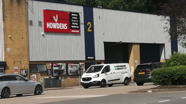 Howdens store exterior in Hillsborough, Sheffield, featuring a sign, delivery van, and parked cars.