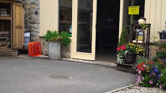 Beadlam Grange Farmshop and Tea Room with a welcoming entrance, stone walls, and vibrant flower pots.