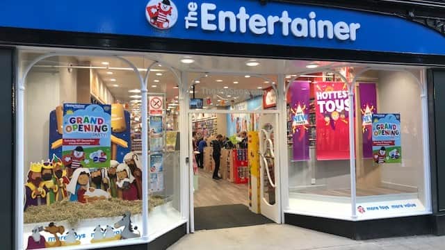 Bright storefront of The Entertainer toy shop in York, featuring colorful displays and a grand opening sign.