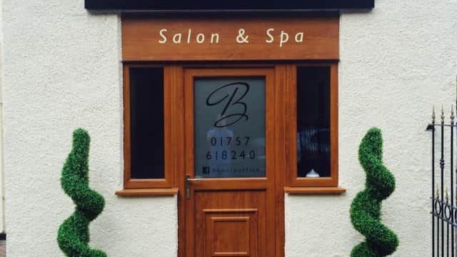 Sign for "Beauty Office" salon and spa, with decorative topiary plants flanking the entrance in Camblesforth, Yorkshire.