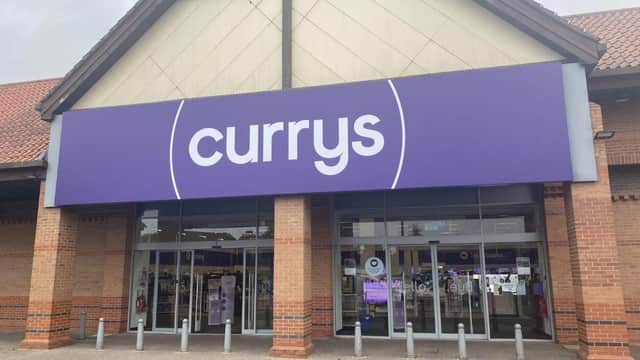 Storefront of Currys in Starbeck, Yorkshire, featuring a large purple sign and brick architecture.