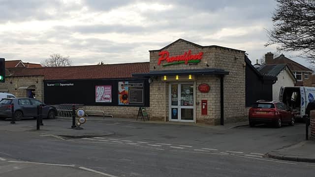 Proudfoot shop in Seamer, Scarborough, featuring a stone facade, parking area, and nearby vehicles.