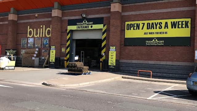 TradePoint Leeds storefront with yellow signage, entrance, and a nearby parked car on a sunny day.