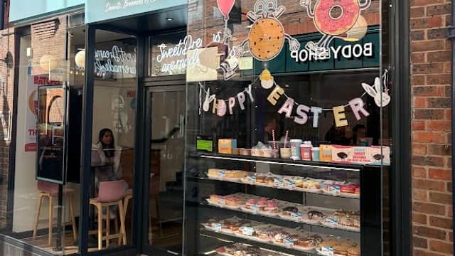 Bright storefront of Batch'd bakery in York, featuring colorful pastries and a festive "Happy Easter" display.