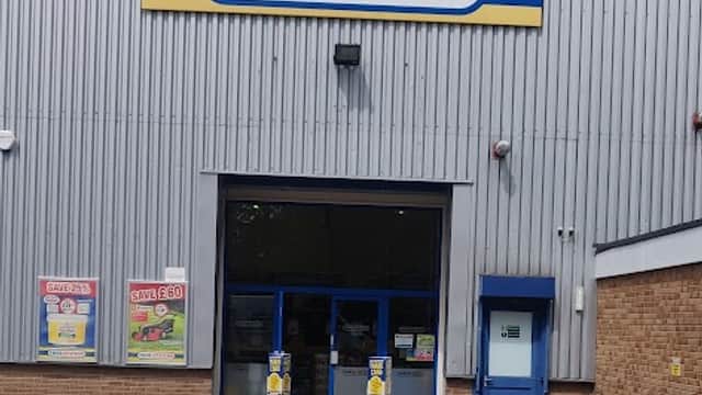 Toolstation storefront with a large sign, blue doors, and a grey metal exterior under a partly cloudy sky.