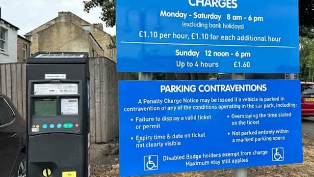 Welcome sign for Bath Street Car Park, with parking charges and payment machine visible. Trees in the background.