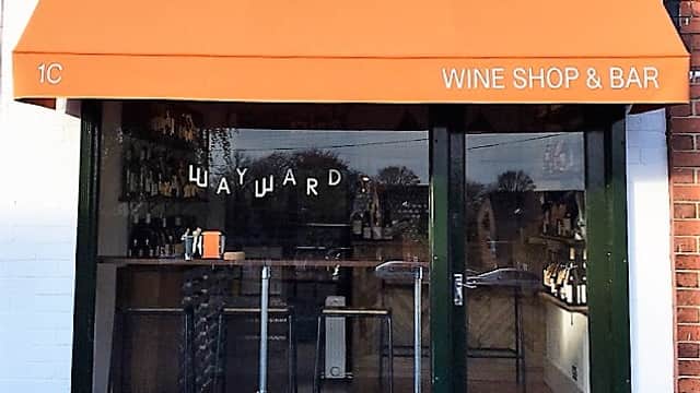 Wayward Wines shop front with an orange awning, displaying "WINE SHOP & BAR" and a welcoming entrance.