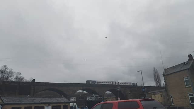 Dalton St Parking with cars, a railway viaduct above, and overcast skies in Todmorden, Yorkshire.