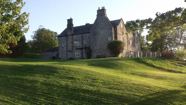 Braithwaite Hall Bed & Breakfast, a stone building surrounded by lush green lawns and trees in Coverham, Yorkshire.