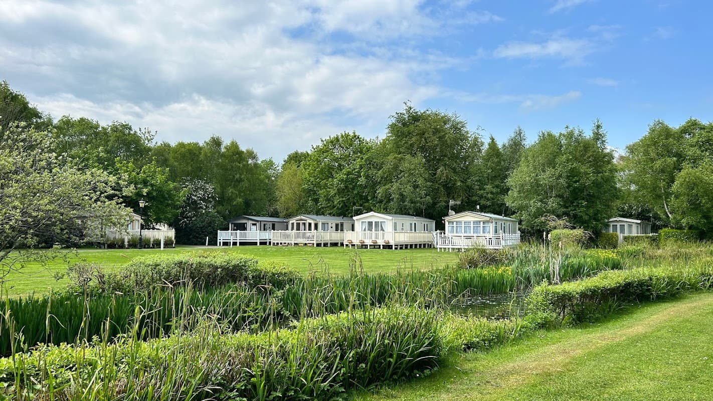 Caravans nestled among lush greenery and trees at Merry Lees Caravan Park in Staxton, Yorkshire.