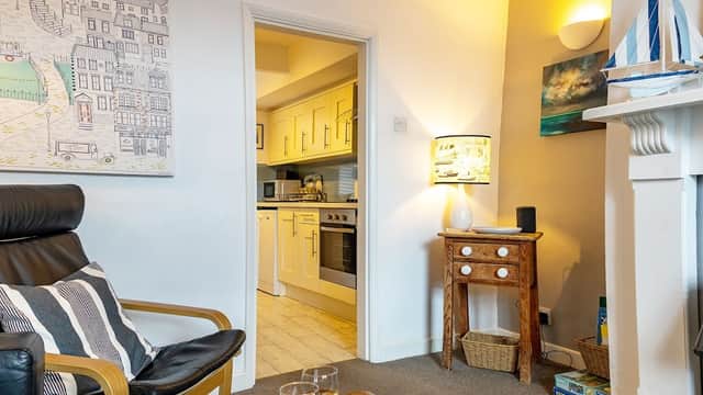 Coastguards Cottage interior featuring a cozy living area, kitchen entrance, and decorative nautical elements.