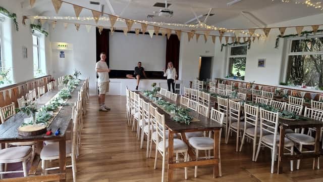 Spacious event venue with wooden tables, chairs, bunting, and fairy lights, set up for a gathering in Bradley, North Yorkshire.