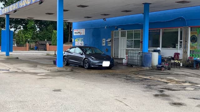 York Road Hand Car Wash with a black car parked in front, blue building, and various cleaning equipment visible.