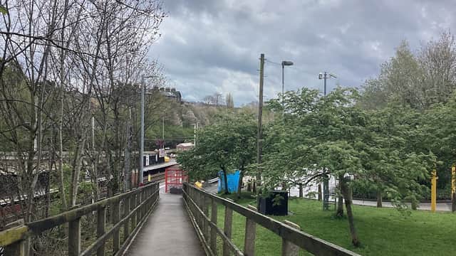Pathway leading to bus stops, surrounded by trees and cloudy skies in East Morton, Yorkshire.