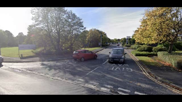 Car park entrance in Edenthorpe, Yorkshire, with trees and parked cars along a winding road.