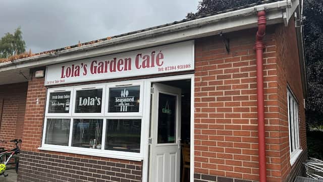 Lola's Garden Café with a brick exterior, large windows, and signage featuring the café's name and contact number.