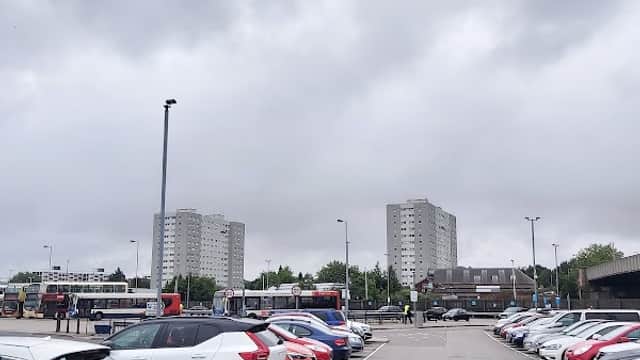 Pay & Display car park in Hull with parked cars, cloudy sky, and tall residential buildings in the background.