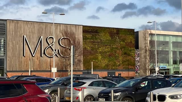 M&S store with a green wall, surrounded by parked cars and a cloudy sky at Vangarde Shopping Park, York.
