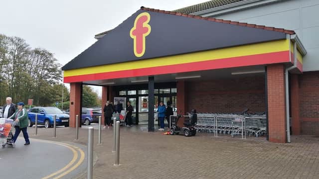 Farmfoods Ltd shop entrance with yellow and red signage, shopping trolleys, and customers outside in Bessingby, Yorkshire.