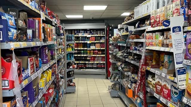 Aisles filled with various products, including snacks, drinks, and household items in a Tesco Express store.
