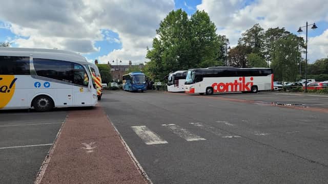 Buses parked in Union Terrace Coach Park, with trees and cloudy sky in the background. Pay & Display signage visible.