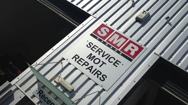 Sign for SMR Garage in Tockwith, Yorkshire, displaying services: 'Service', MOT, Repairs, with a reception area visible.