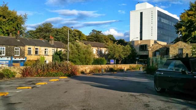 St Anne's Car Park in Headingley, featuring trees, buildings, and a modern hotel in the background under a blue sky.