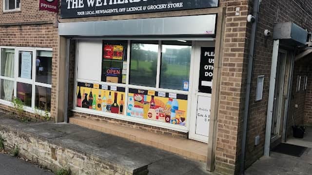 Corner shop with a sign reading "The Wetherby Local," displaying groceries and drinks, in a brick building.