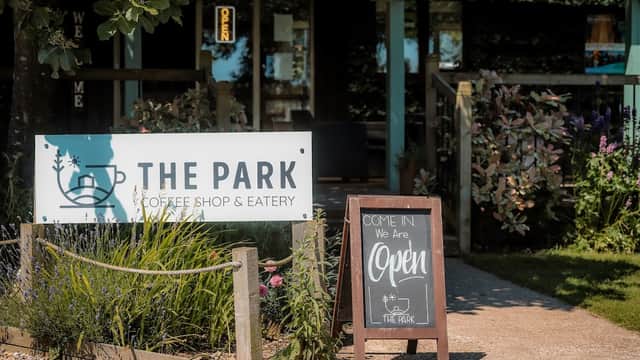 Sign for The Park Coffee Shop & Eatery, with a welcoming entrance and lush greenery in Wykeham, Yorkshire.