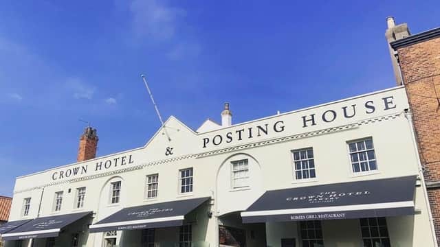 Crown Hotel & Posting House exterior with blue sky, awnings, and outdoor seating in Austerfield, Yorkshire.