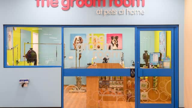 Brightly colored storefront of The Groom Room, featuring a glass entrance and pet grooming signage.