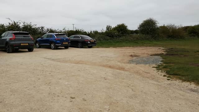 Pay & Display parking area with several parked cars and grassy surroundings in Flamborough, Yorkshire.