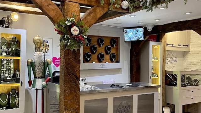Handmade silver jewellery display in a charming shop with wooden beams and festive decorations.