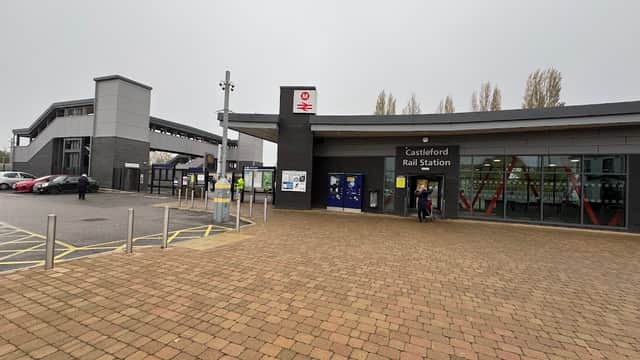 Castleford Rail Station entrance with modern architecture, surrounded by a paved area and bus stops nearby.