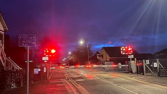 Brough Station Long Stay Car Park entrance at night, with red signal lights and a barrier across the road.