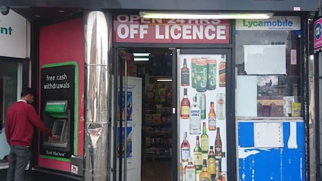 Signage for "BOOZE 4 YOU" with 24-hour off-license, featuring bottles displayed at the entrance and a newsagent section.