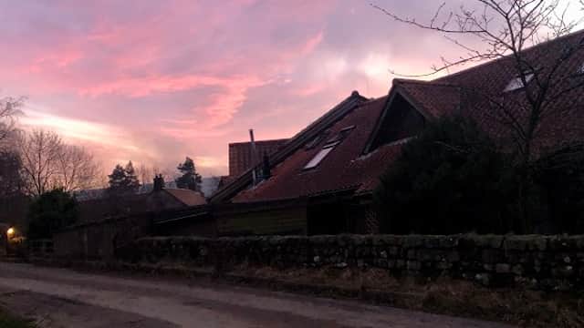 Charming village store with a rustic building against a vibrant sunset sky in Botton, North Yorkshire.