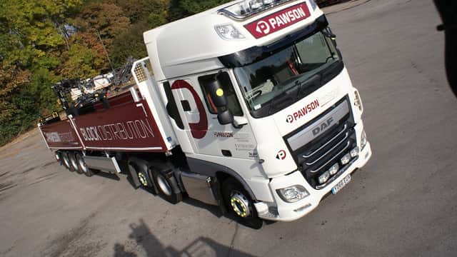White DAF truck with "Pawson Transport" branding, parked in a lot with trees in the background.