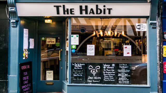 Exterior view of The Habit Cafe Bar with a welcoming entrance, menu boards, and colorful signage in York, Yorkshire.