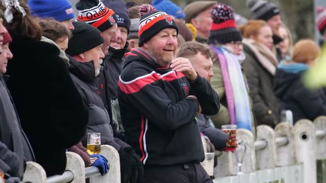 Crowd of spectators wearing hats and coats, enjoying a rugby match at Malton & Norton RUFC in Old Malton.