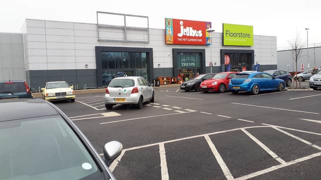 Jollyes pet supermarket and Floorstore signage at Beck Retail Park, with parked cars in the foreground.