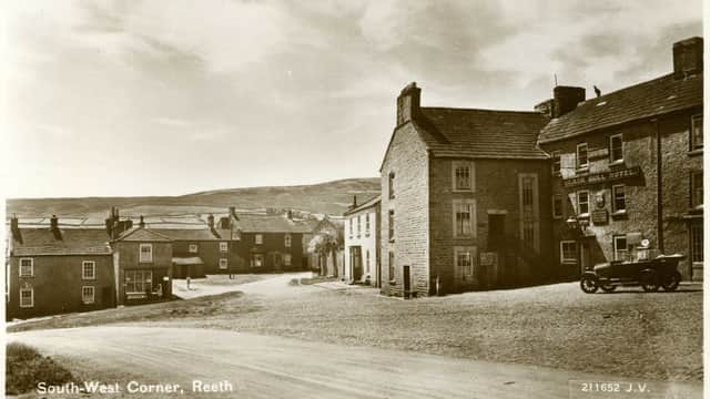 Historic street scene in Reeth, Yorkshire, featuring The Black Bull restaurant and surrounding stone buildings.